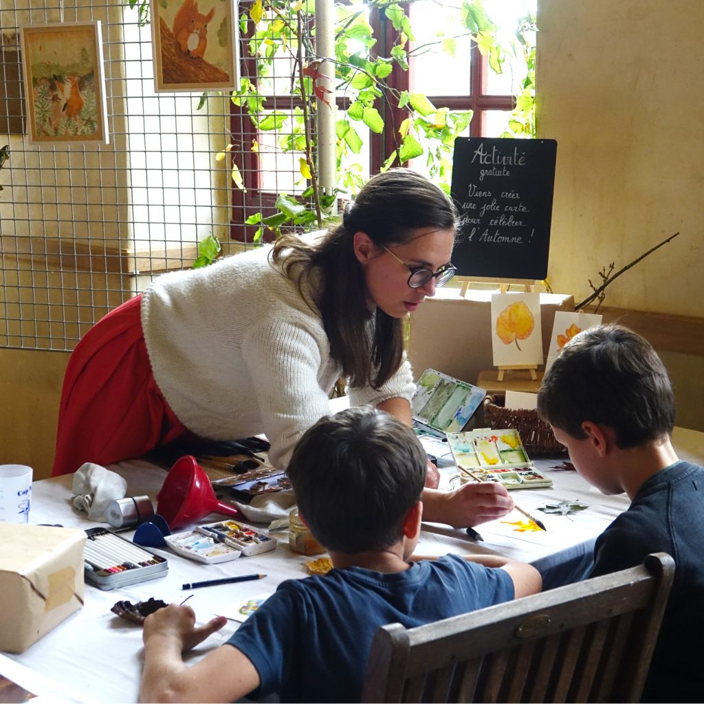 moi penchée vers les enfants avec qui je fais un atelier d'aquarelle au château de Craon