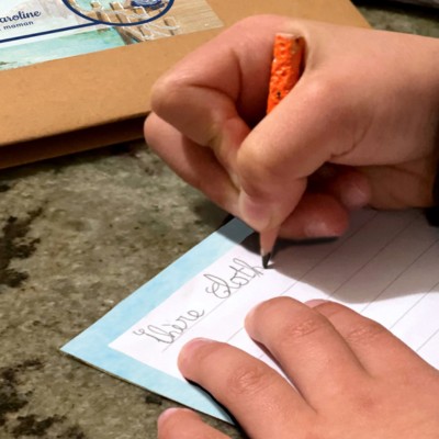 une petite fille qui écrit une lettre sur le papier à lettres de l'atelier