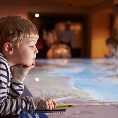 jeune garçon observant un planisphère dans un musée